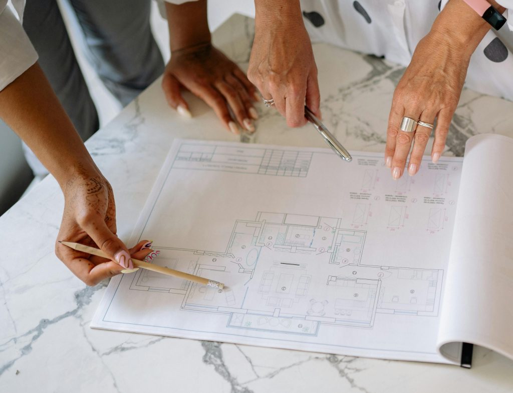 Women collaborating on architectural plans, emphasizing teamwork and precision.